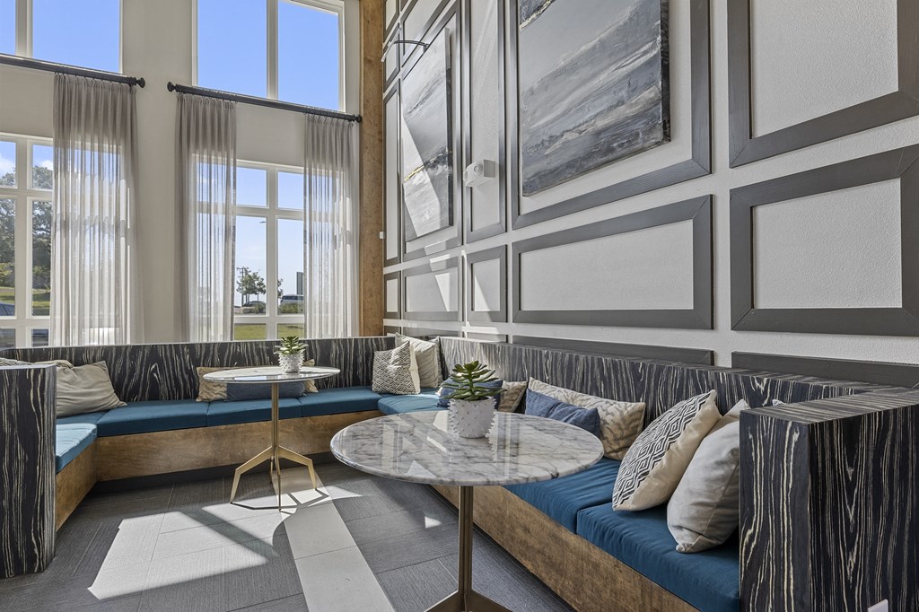 a lobby with couches and tables and windows