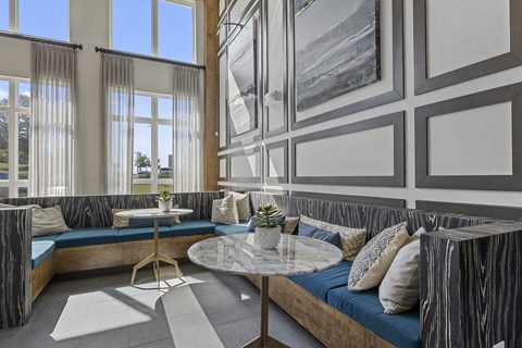 a lobby with couches and tables and windows