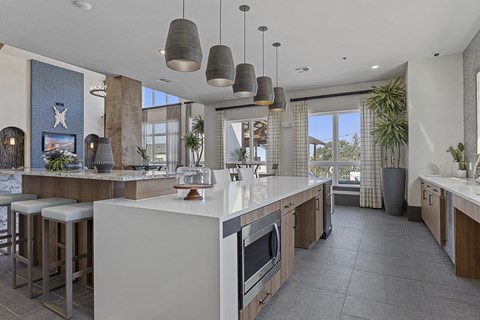 a large kitchen with a large island and a table with stools