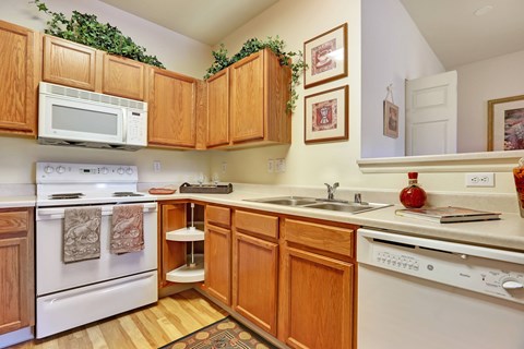A kitchen with wooden cabinets and white appliances.
