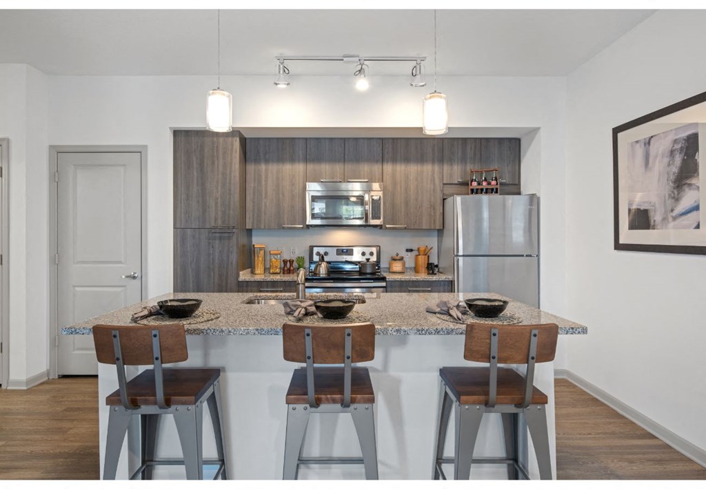 a kitchen with a counter top with bar stools
