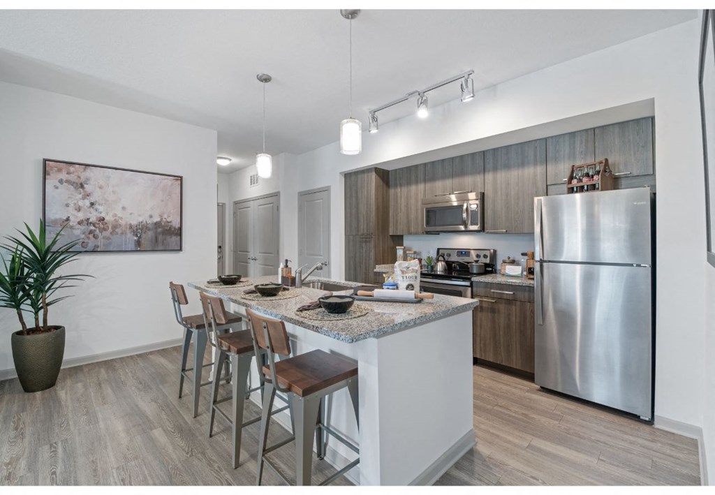 a kitchen with stainless steel appliances and an island with bar stools