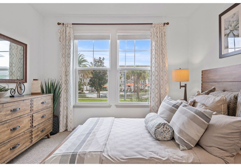 a bedroom with a bed and three windows