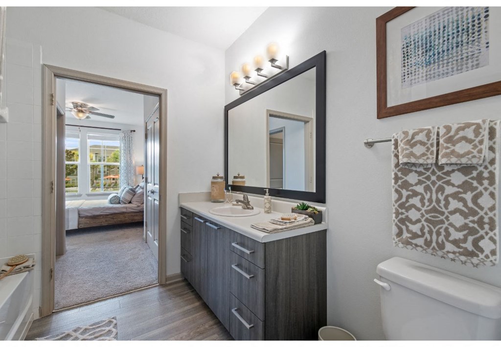 a bathroom with a large mirror and a toilet and a sink