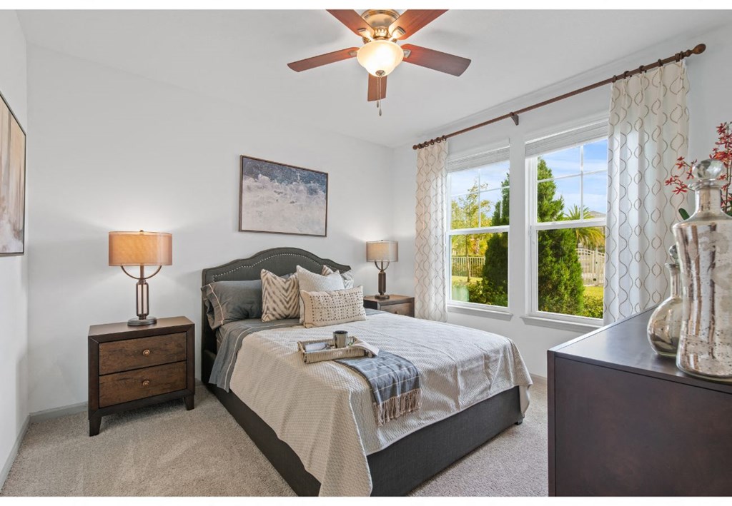 a bedroom with a bed and a ceiling fan
