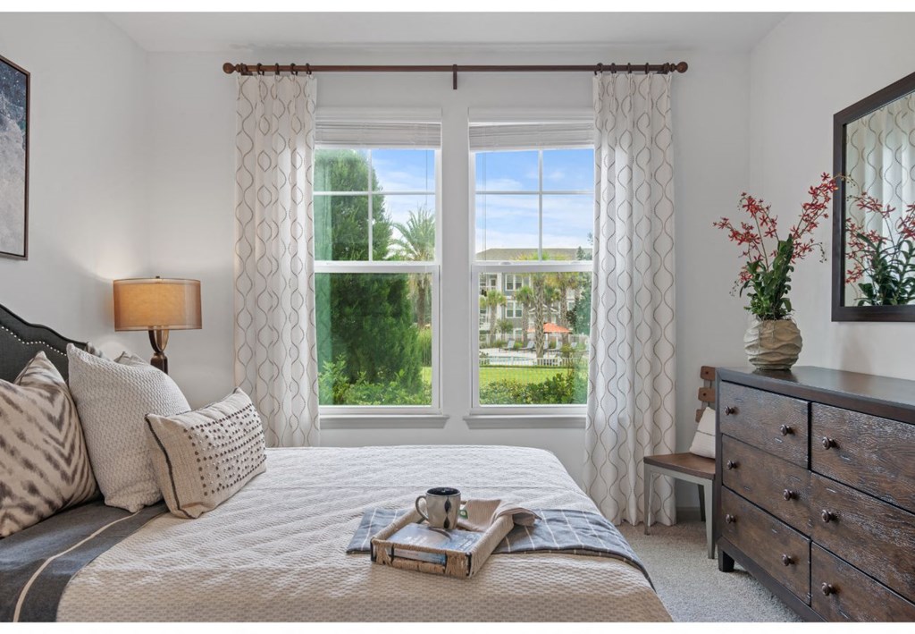 a bedroom with a bed and three windows