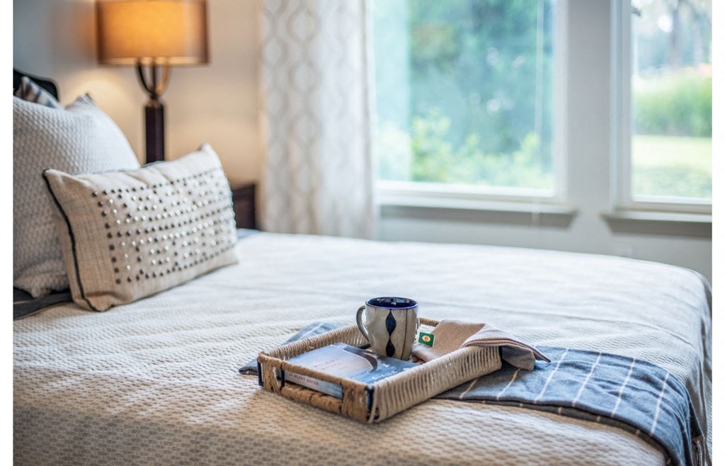 a bed with a tray and a cup of coffee on it