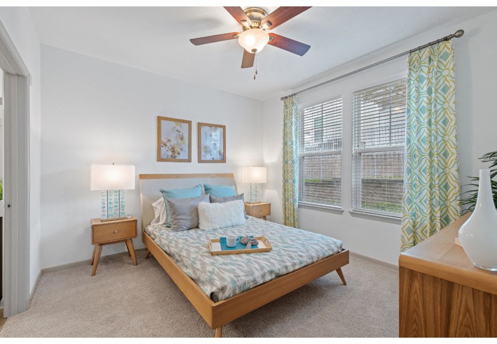 a bedroom with a bed and a ceiling fan