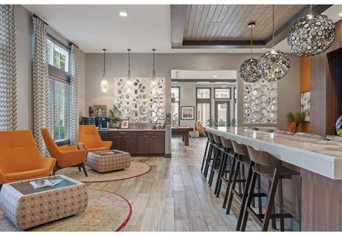 a lobby with a bar and chairs and a kitchen