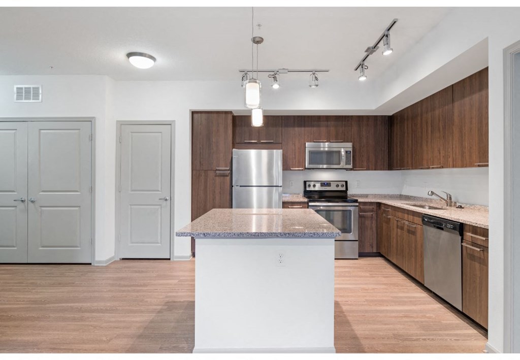 a kitchen with a white island and wooden cabinets