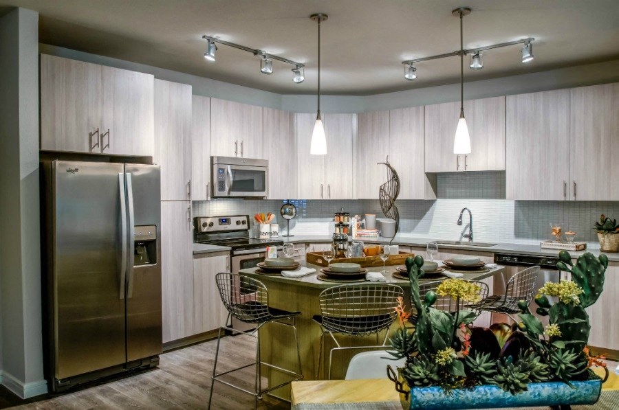 a kitchen with stainless steel appliances and a table with chairs