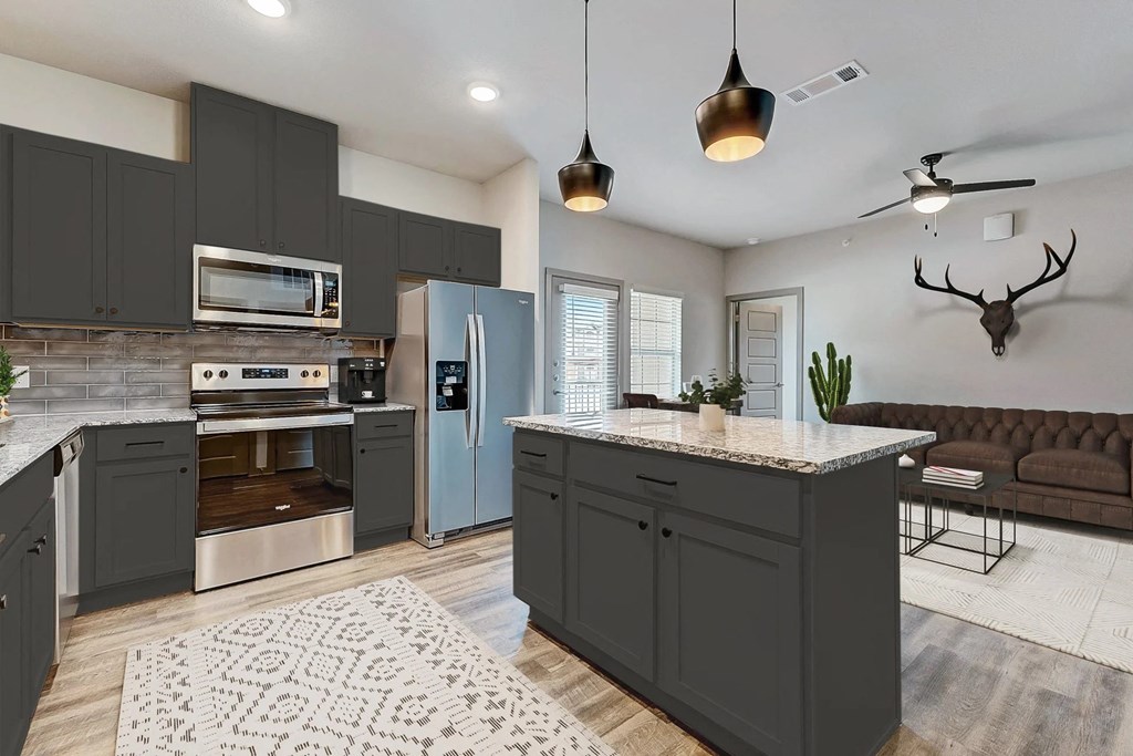 a kitchen with gray cabinets and stainless steel appliances