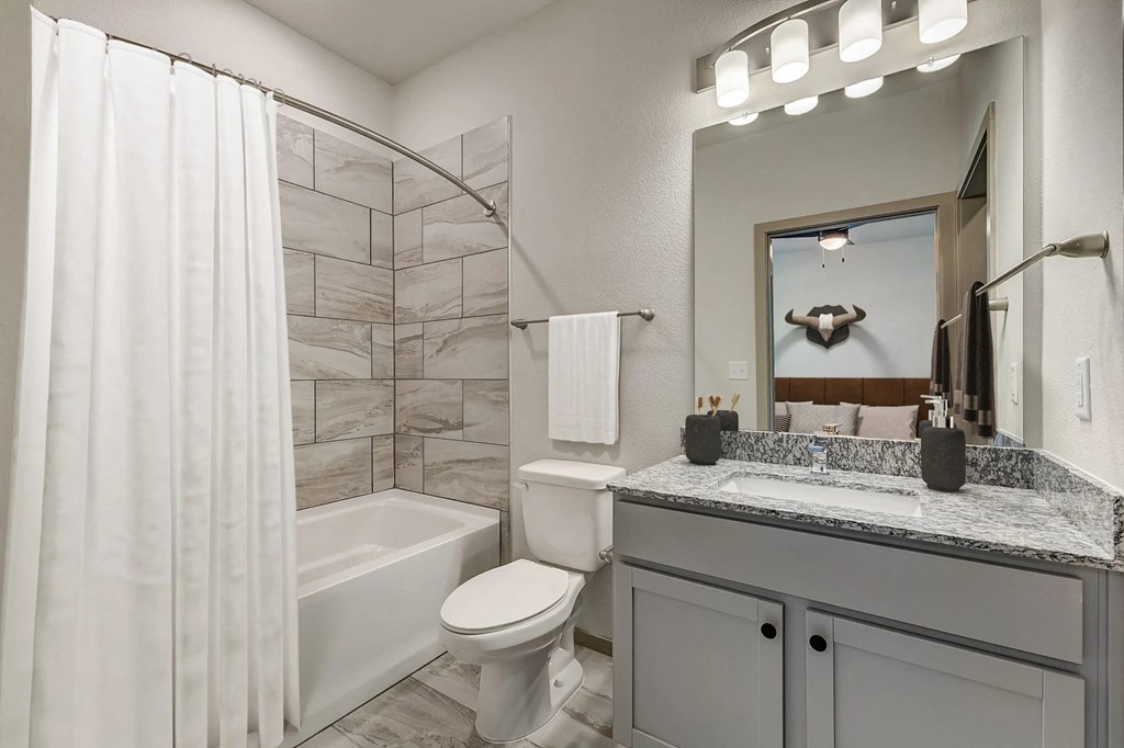 a bathroom with a shower and a toilet and a sink