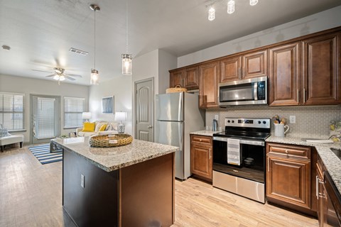an open kitchen with stainless steel appliances and granite counter tops