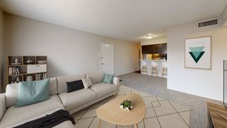 a living room with a couch coffee table and a kitchen in the background