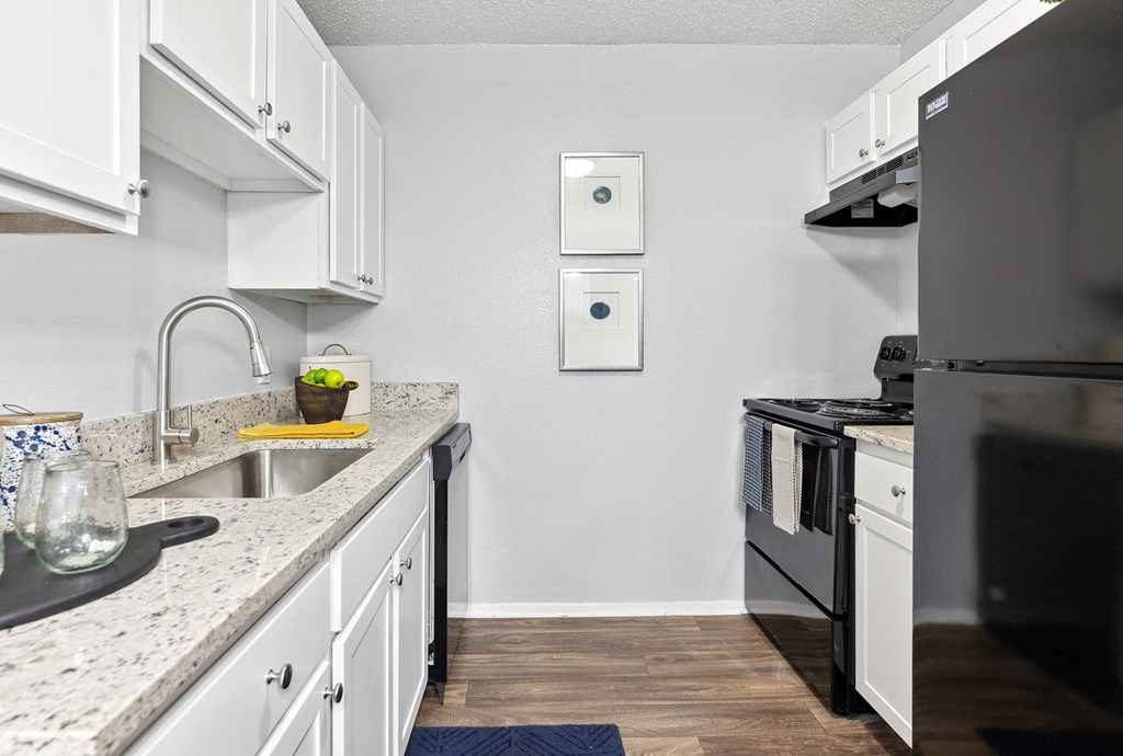 a kitchen with white cabinets and black appliances