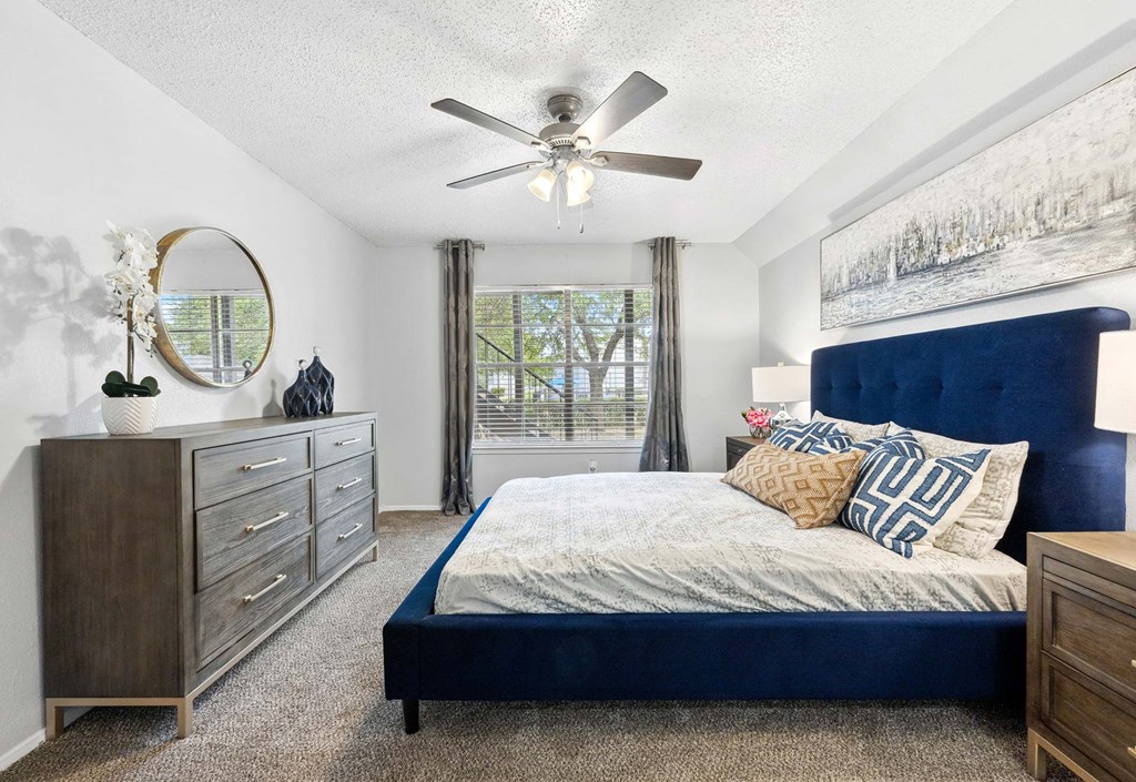 a bedroom with a bed and a ceiling fan