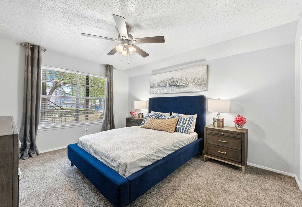 a bedroom with a bed and a ceiling fan