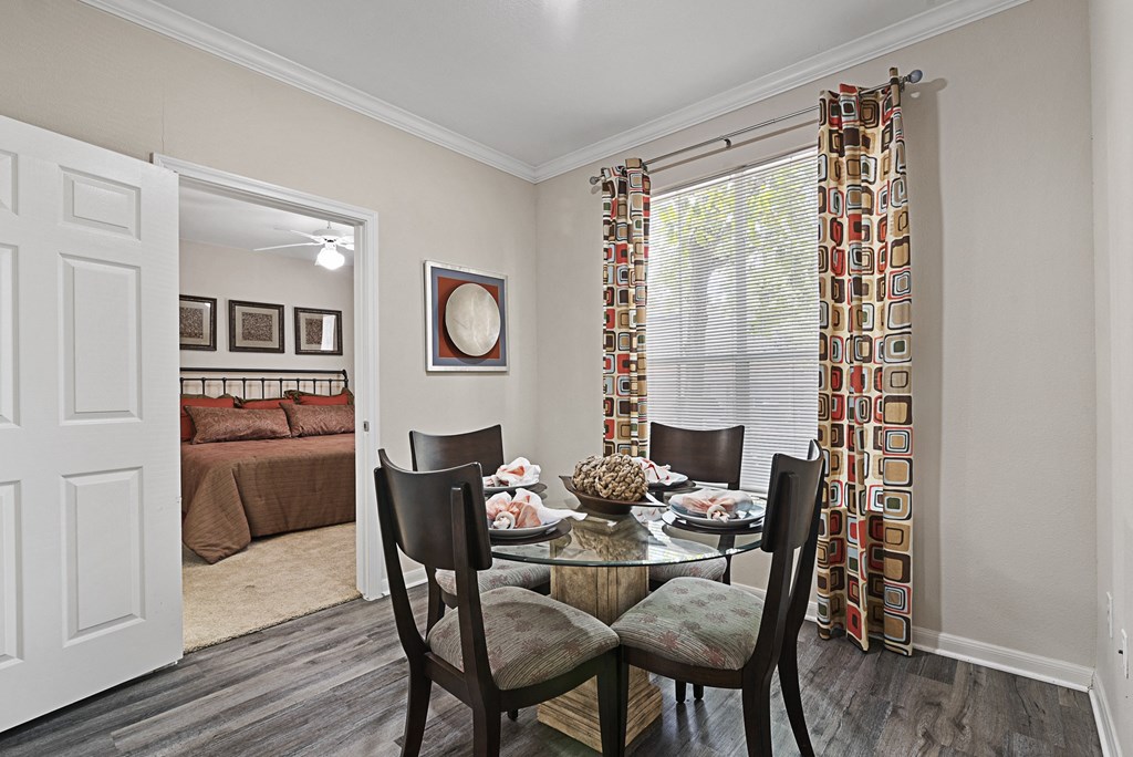 a dining room with a table and chairs and a bedroom with a bed