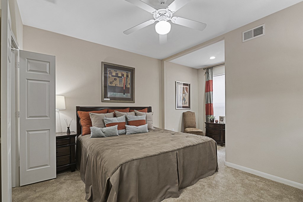 a bedroom with a large bed and a ceiling fan
