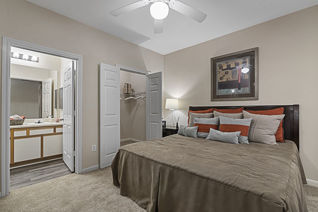 a bedroom with a large bed and a ceiling fan