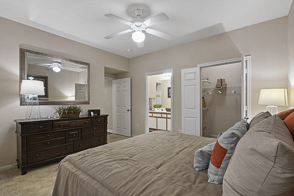 a bedroom with a large bed and a ceiling fan