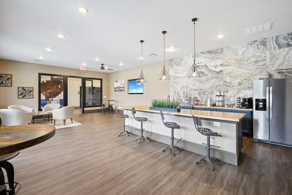 a kitchen and living room with a bar and a refrigerator