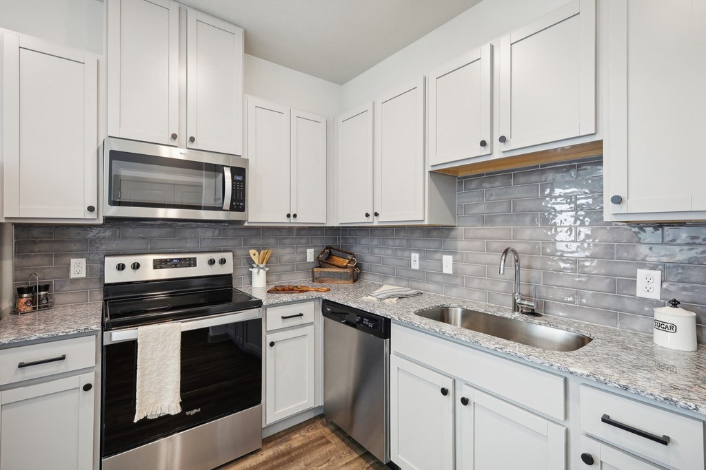 a kitchen with white cabinets and stainless steel appliances