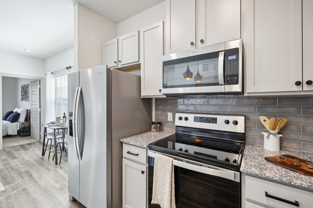 a kitchen with stainless steel appliances and white cabinets