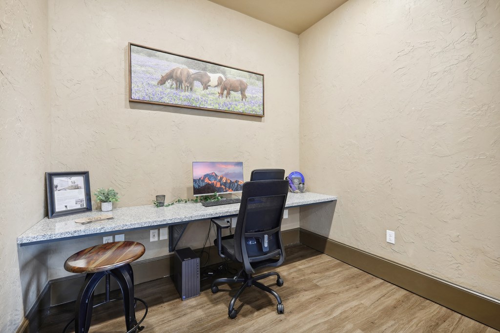 a home office with a desk and a painting on the wall