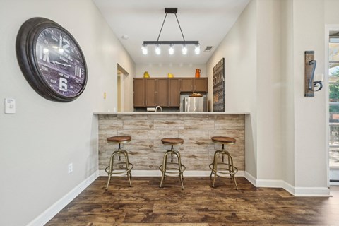 a bar with three stools in front of a counter with bar stools