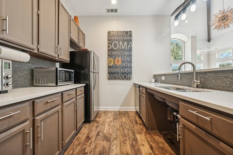 a kitchen with wooden cabinets and a sink and a refrigerator