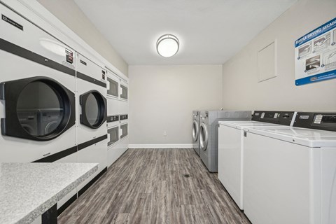 a laundry room with washers and dryers and a counter top with laundry machines