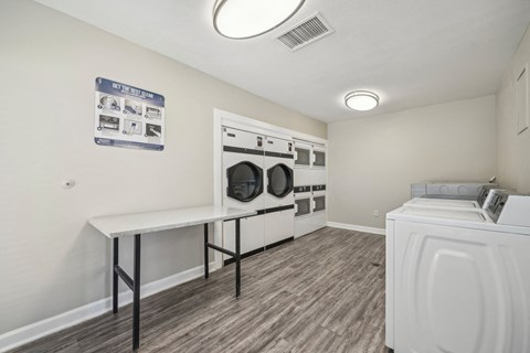 a washer and dryer in a laundry room with white walls and wood floors