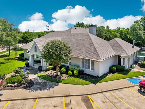 a white house with a driveway and a tree in front of it