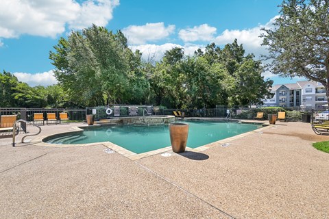 a swimming pool with trees and a building in the background