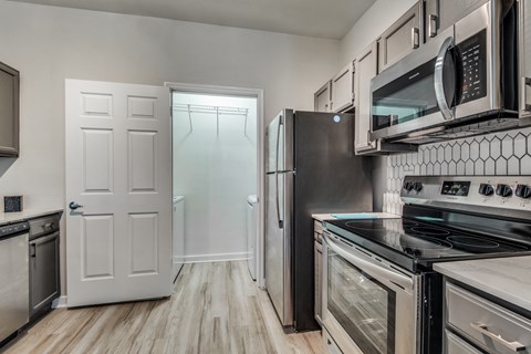 A kitchen with a black stove top oven and a black refrigerator.