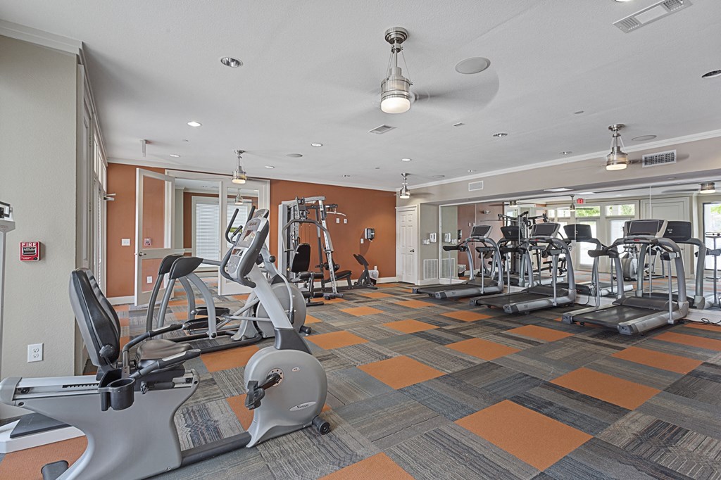 a gym with treadmills and other exercise equipment at the enclave at university heights