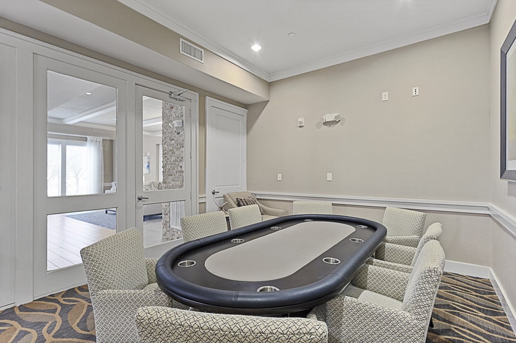 a game room with a poker table and chairs