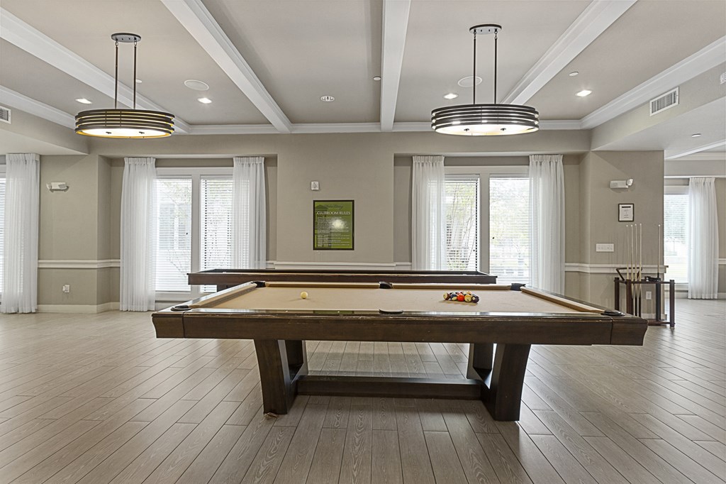 a game room with a pool table and windows