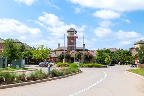 A street view of a town with a clock tower in the background.