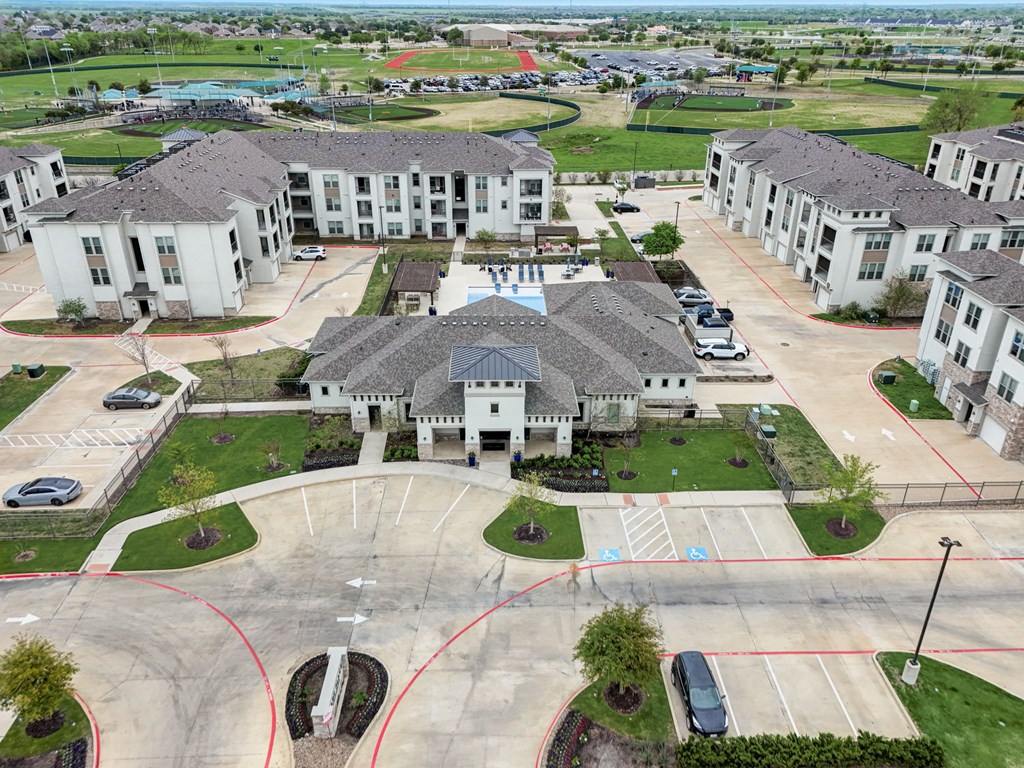 an aerial view of a neighborhood of houses with cars in a parking lot