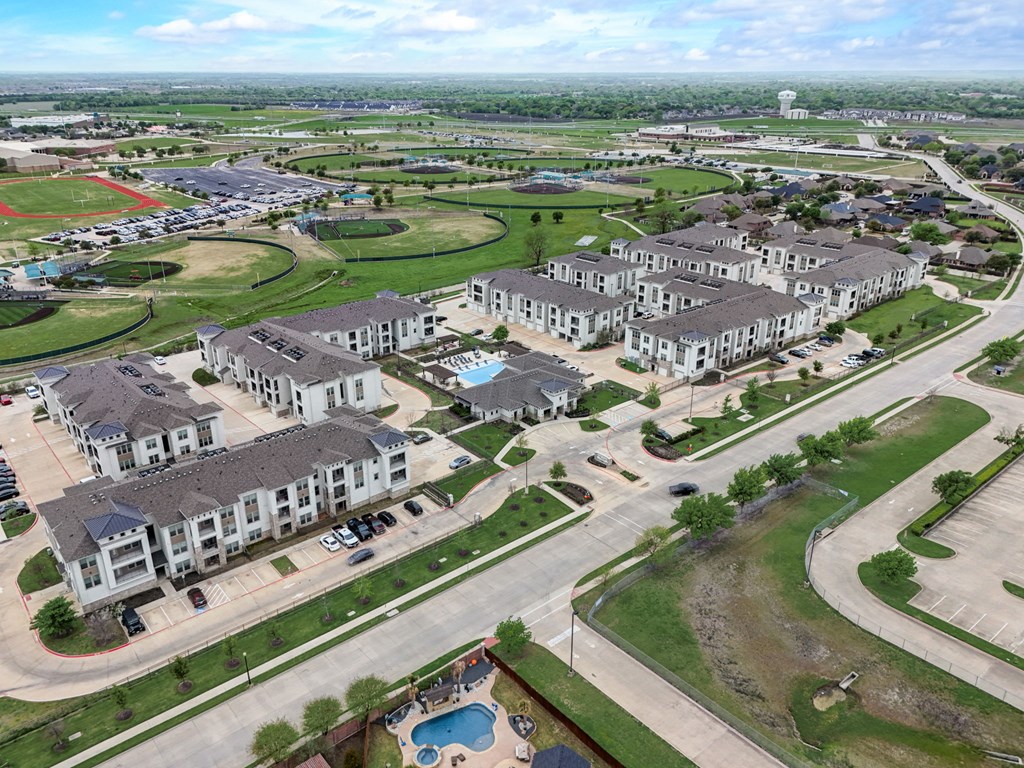 an aerial view of a city with houses and a parking lot