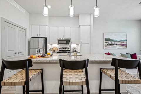 a kitchen with a marble counter top with three stools