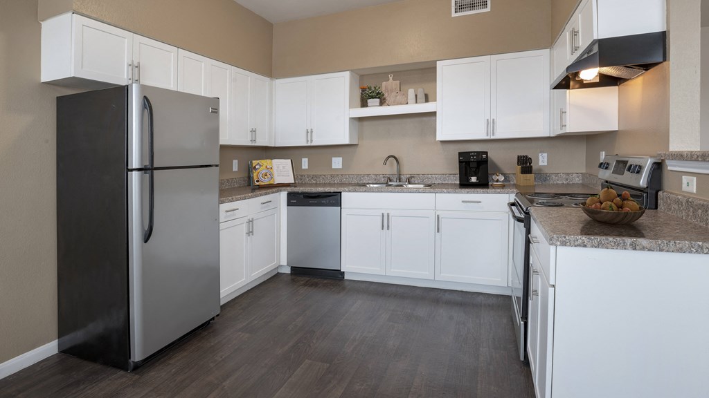 a kitchen with white cabinets and a stainless steel refrigerator