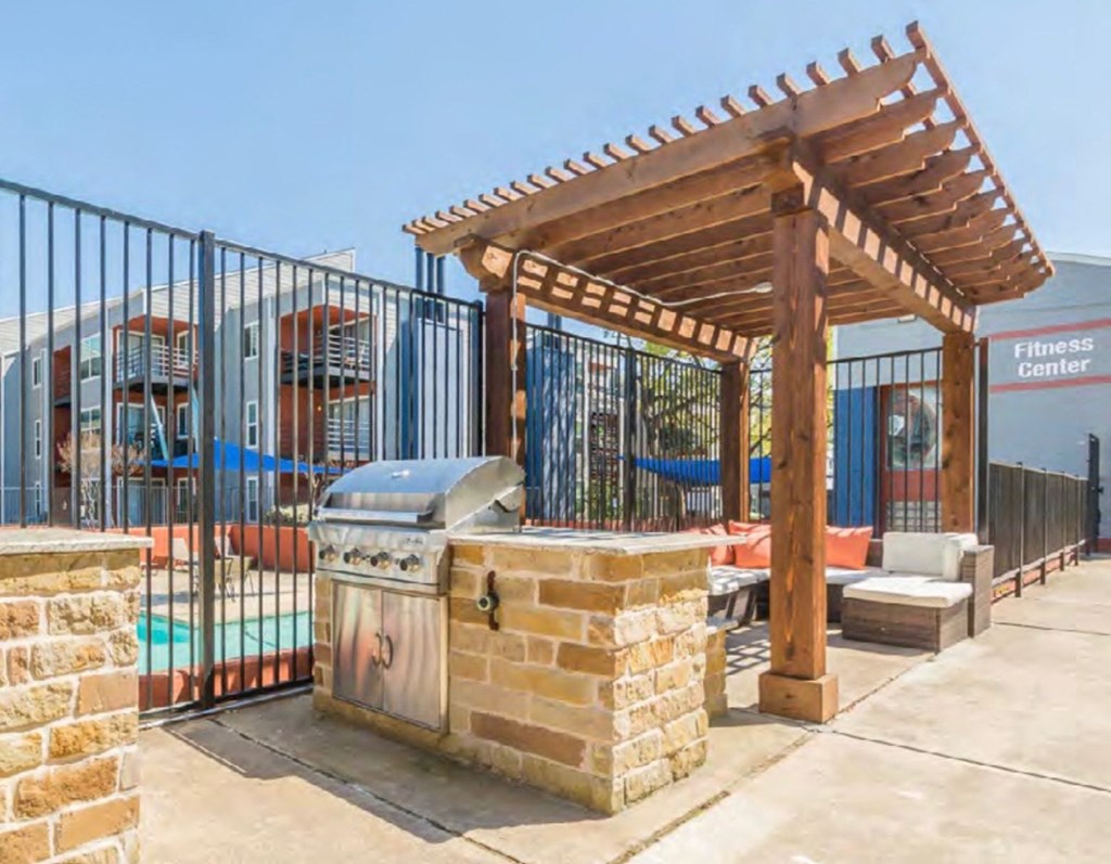 a barbecue grill is under a wooden pavilion near a swimming pool