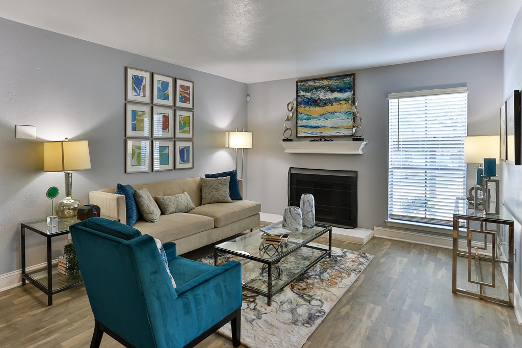A living room with a blue chair and a fireplace.