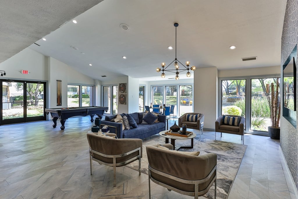 A living room with a blue couch and a chandelier.