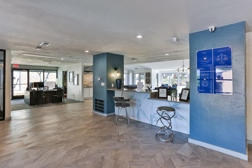 A blue wall with a white counter and a bar stool in front of it.