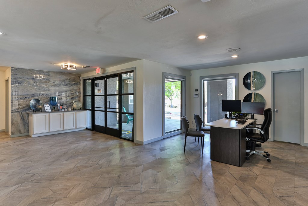 A room with a desk and chairs in it.